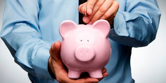 Man putting a coin in a piggy bank