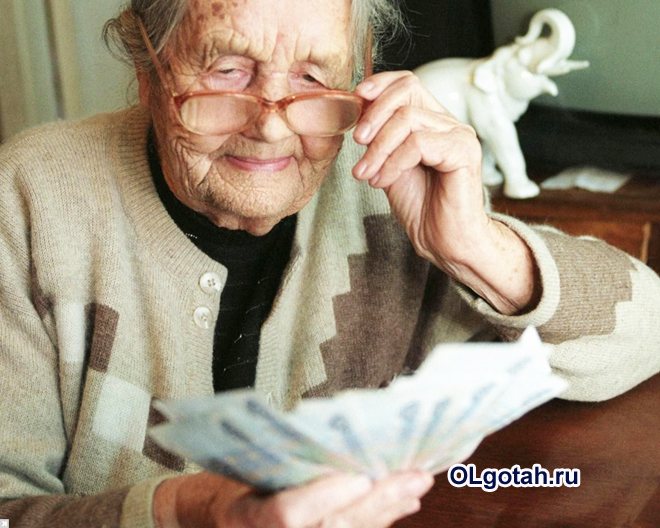 Пенсионерка смотрит на деньги